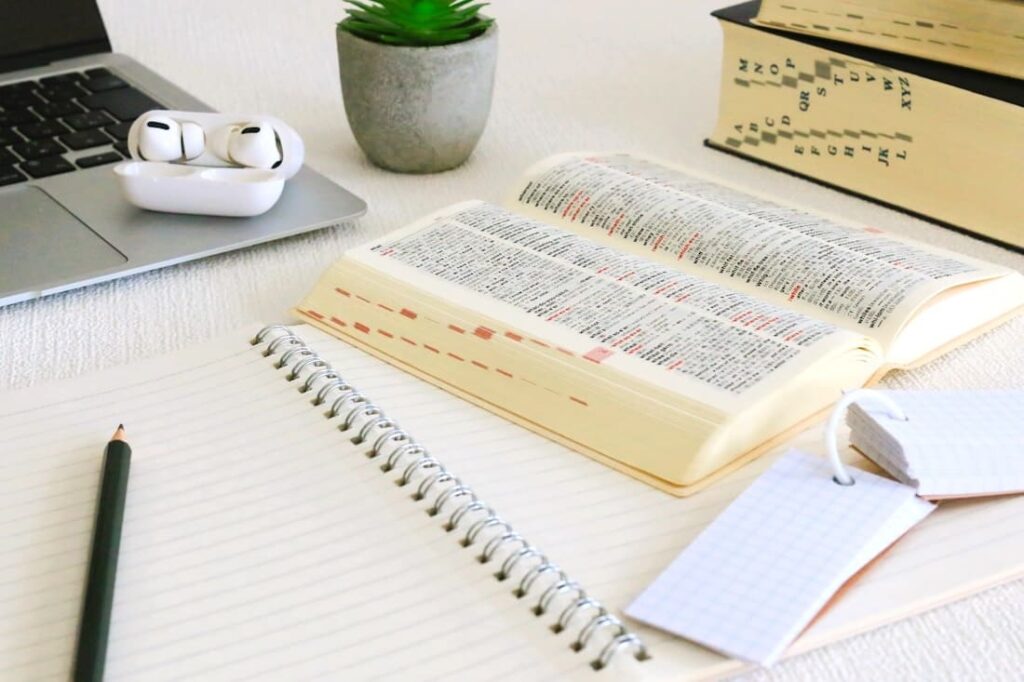 ノートと辞典、単語帳を広げ、勉強している様子の机の写真