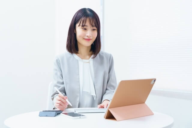 タブレットを開いて学習する女性の写真